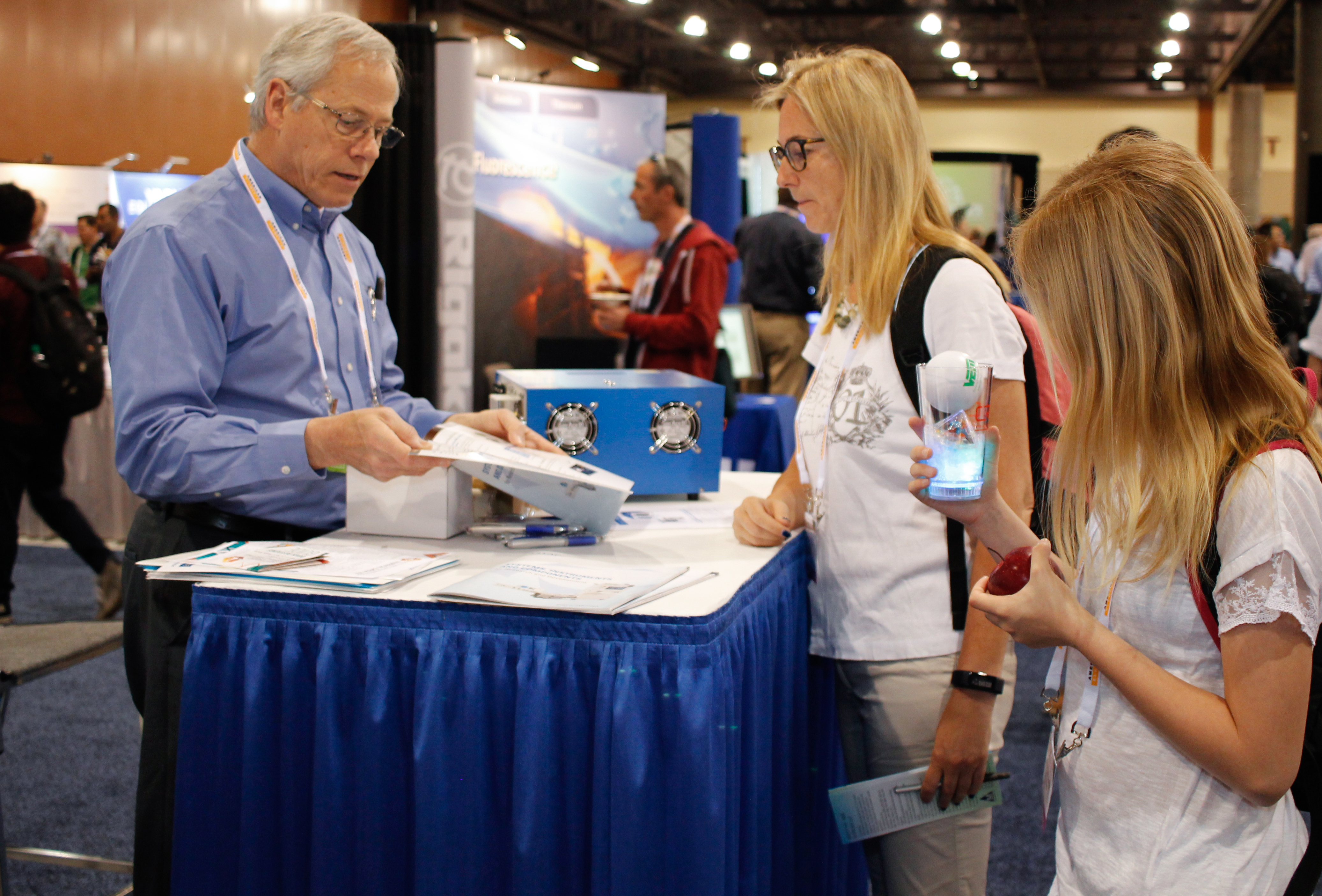 Man demonstrating a product to two women